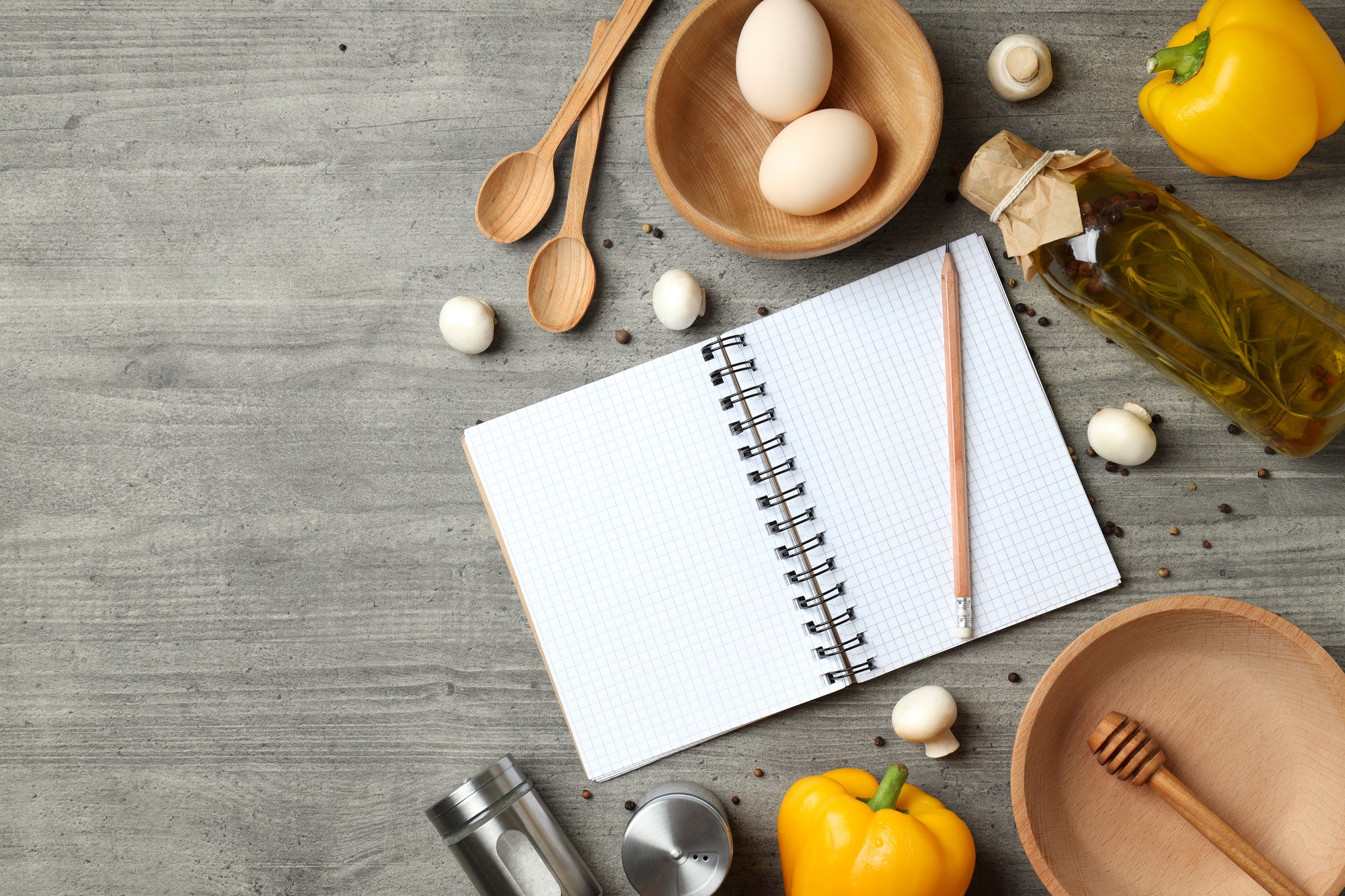 Tavolo con utensili da cucina e quaderno di appunti